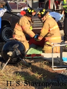 Firefighters removing a victim onto a back board.